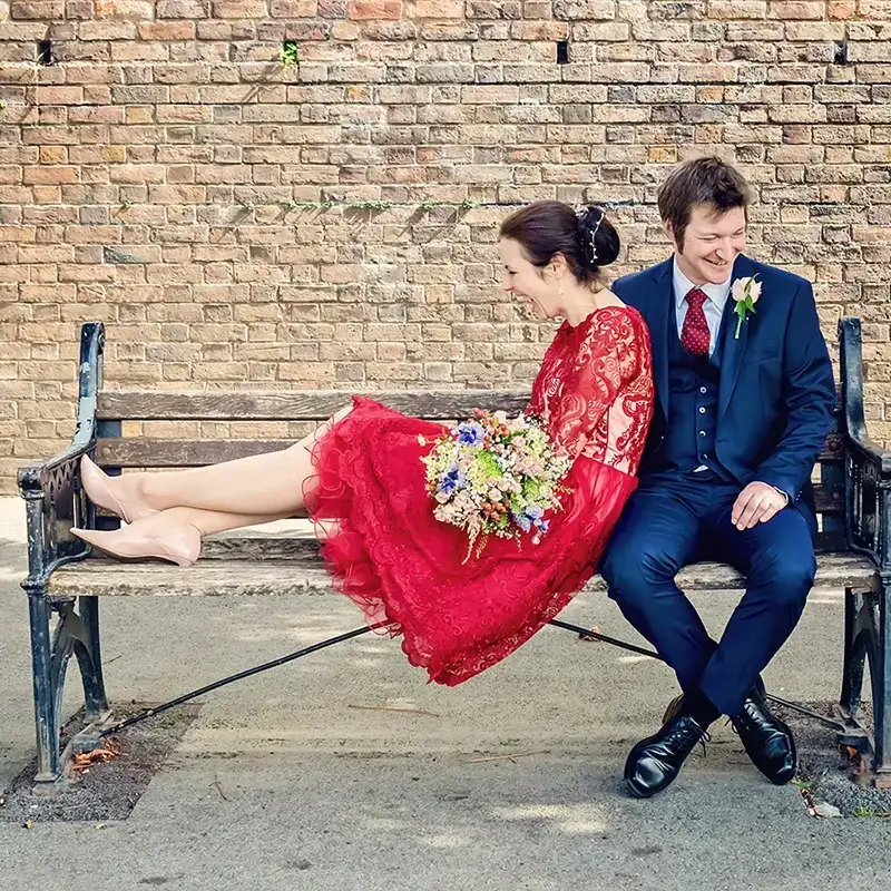Newlyweds sitting on a bench by the River Severn in Worcester