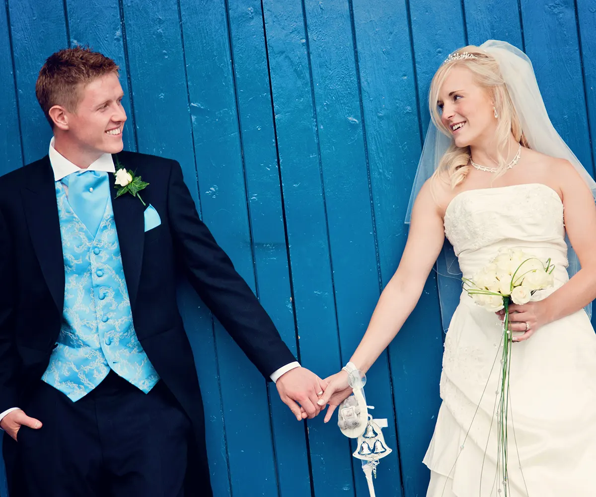 Bride and groom holding hands by Worcester rowing club